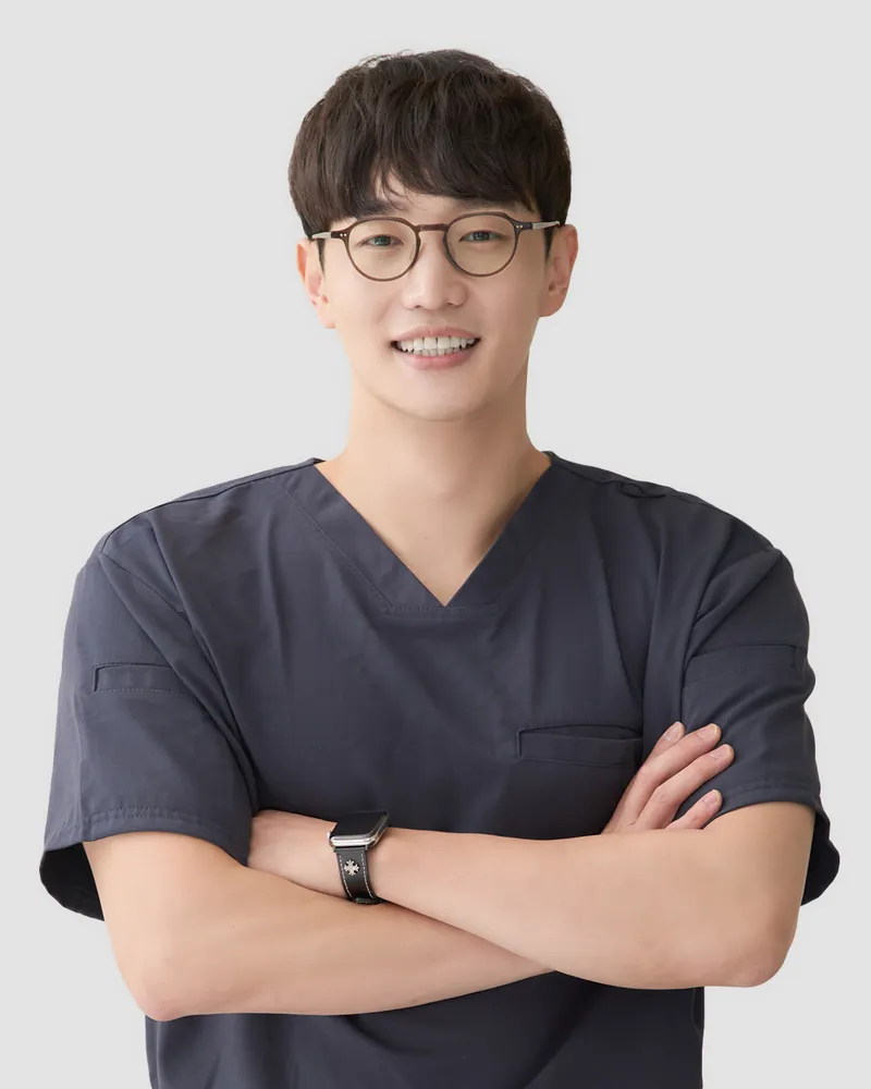 다리핏의원 서동주 대표원장 — 회색 수술복 차림으로 팔짱을 끼고 미소 짓는 흉부외과 전문의 프로필 사진